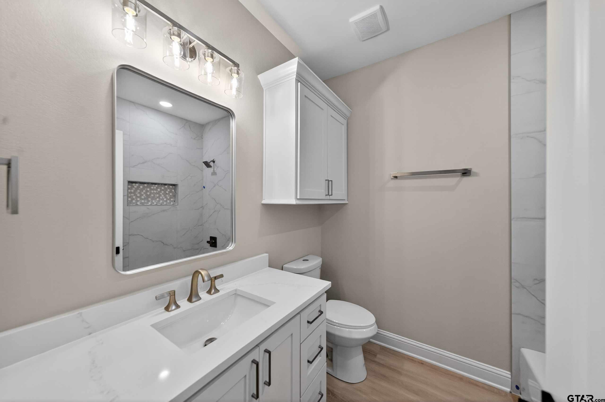 3049 Guinn Farms Road Tyler, TX 75707 - Photo 37 of 43 a bathroom with a toilet a sink and mirror