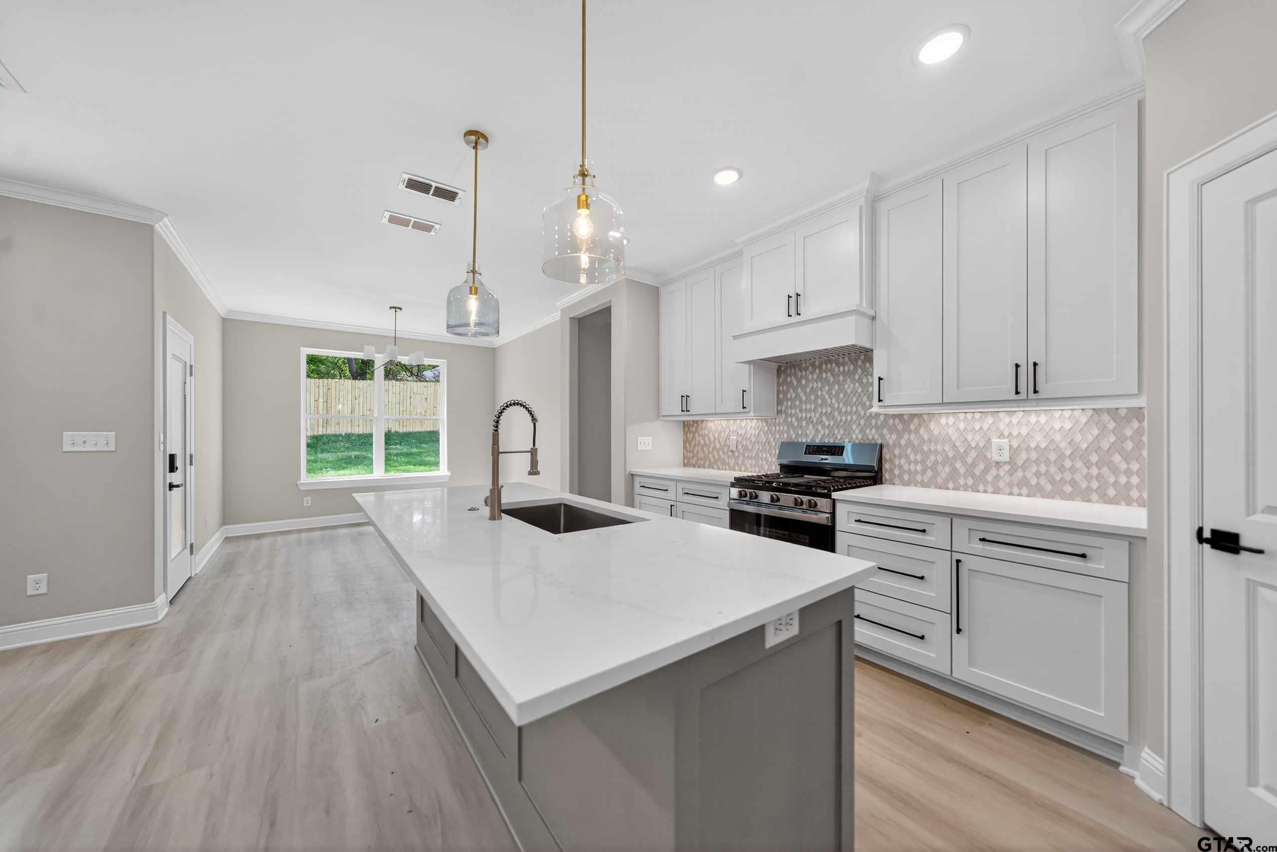 3049 Guinn Farms Road Tyler, TX 75707 - Photo 10 of 43 a kitchen with a stove a sink and a refrigerator