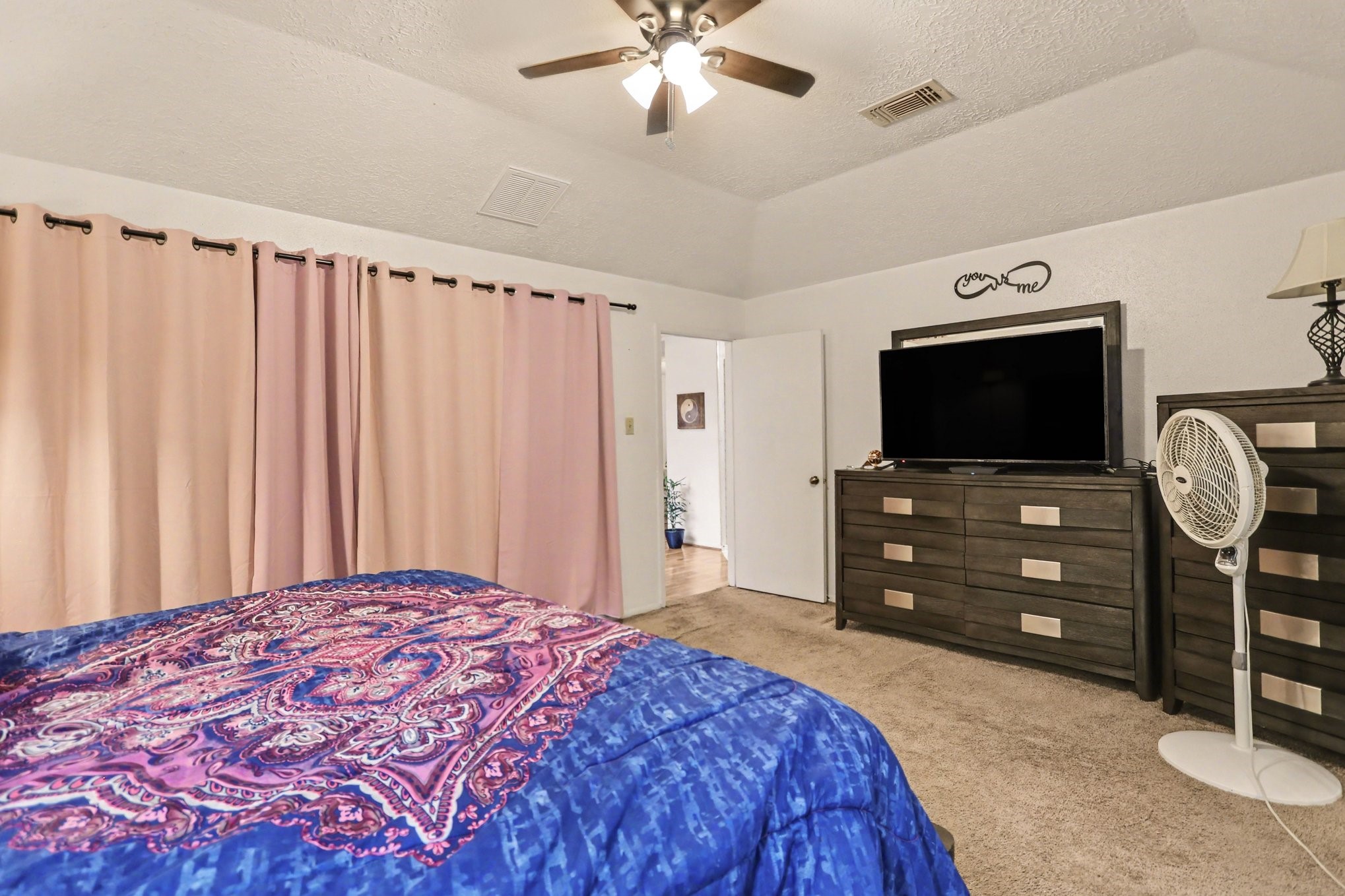 12151 Swords Creek Road Houston, TX 77067 - Photo 12 of 20 a bedroom with a bed and a flat tv screen on dresser