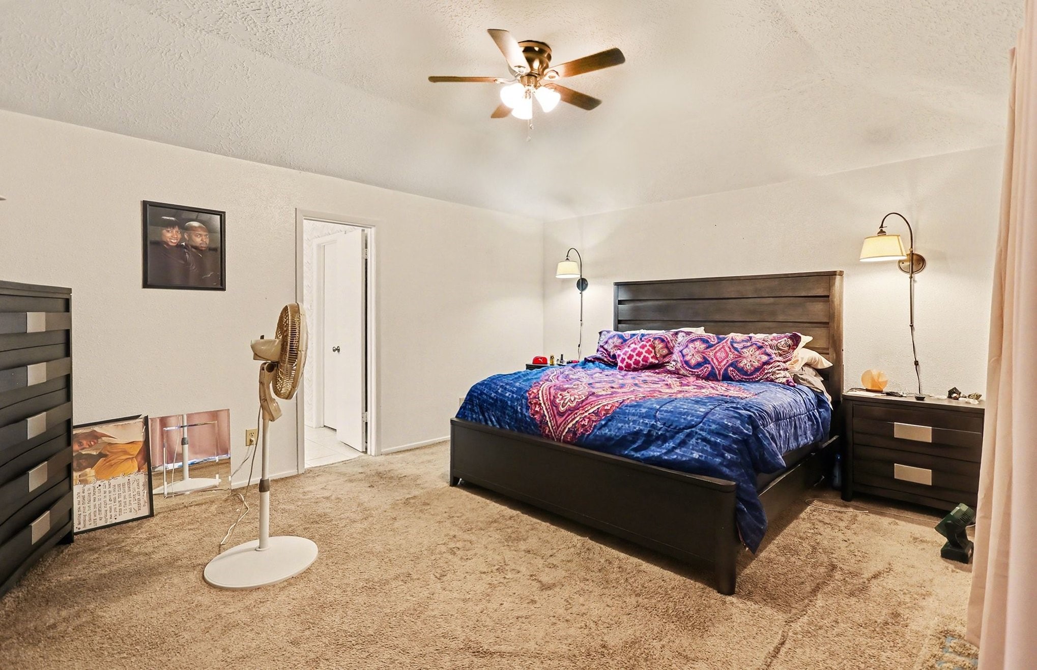 12151 Swords Creek Road Houston, TX 77067 - Photo 10 of 20 a bedroom with a bed a chandelier and dresser
