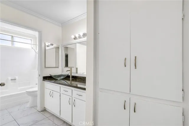 a bathroom with a granite countertop sink a mirror and a bathtub
