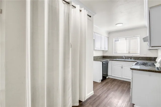 a kitchen with granite countertop white cabinets and white appliances