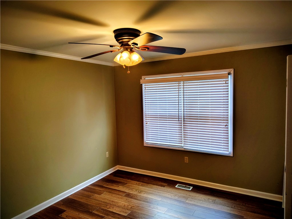 This inviting room features warm flooring and natural light, creating a comfortable living space.
