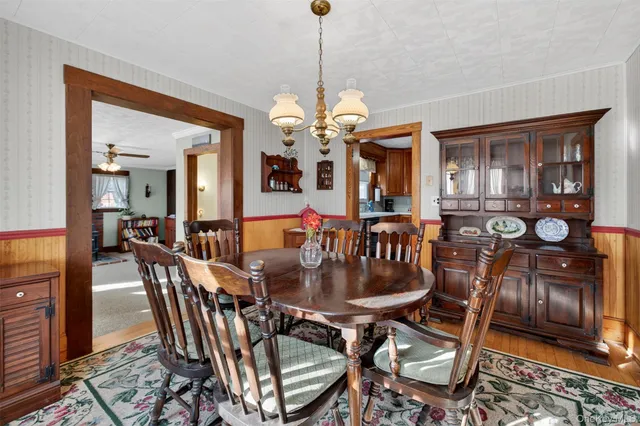a dining room with furniture a chandelier and wooden floor