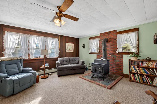 a living room with furniture a ceiling fan a flat screen tv and a window