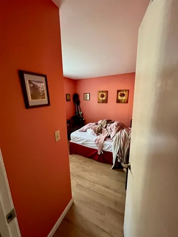 a bedroom with a bed and a wall painting