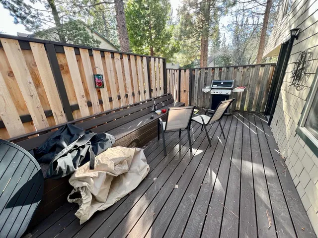 a balcony with wooden floor table and chairs