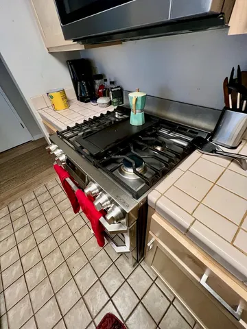 a stove top oven sitting inside of a kitchen