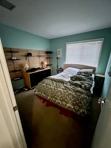 a bed sitting in a bedroom next to a window