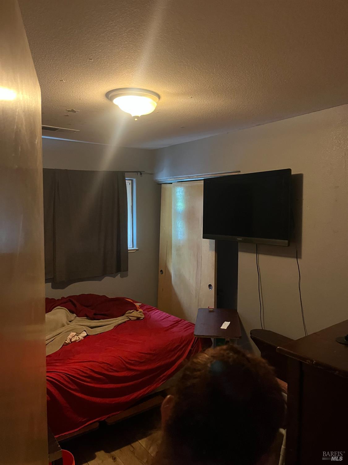 1889 Jennings Avenue Santa Rosa, CA 95401 - Photo 7 of 10 a bedroom with a bed and a flat screen tv