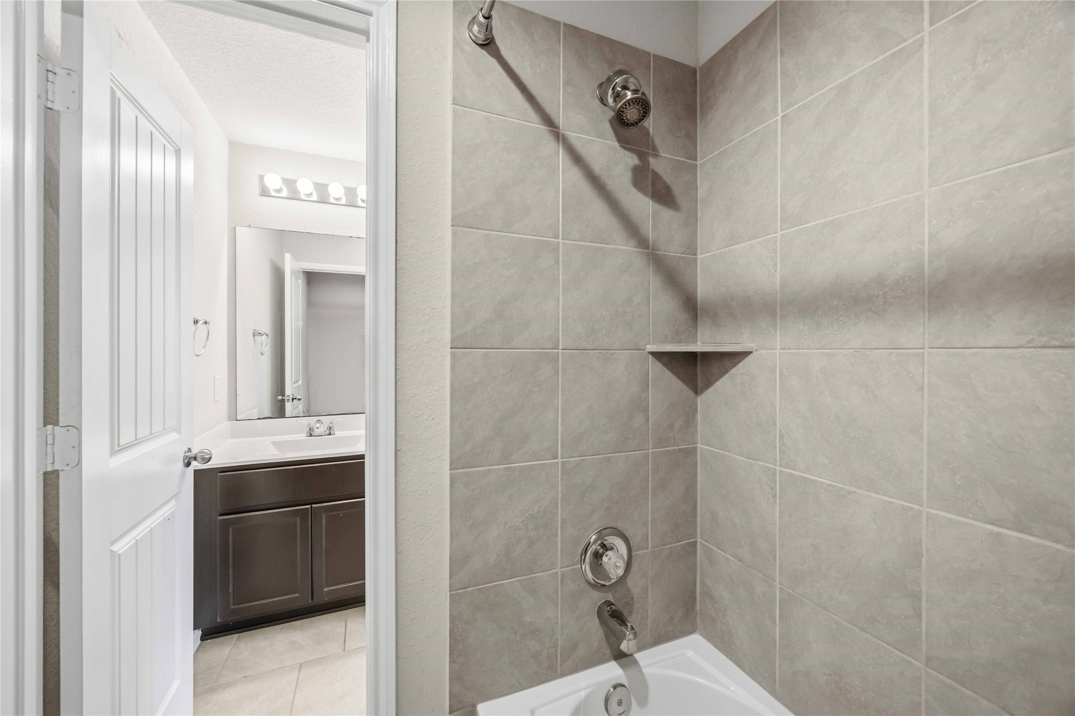 703 Autumn Flats Way Rosharon, TX 77583 - Photo 15 of 18 The adjacent shower and soaking tub are finished with timeless neutral tiling, offering a move-in-ready space for guests or family.