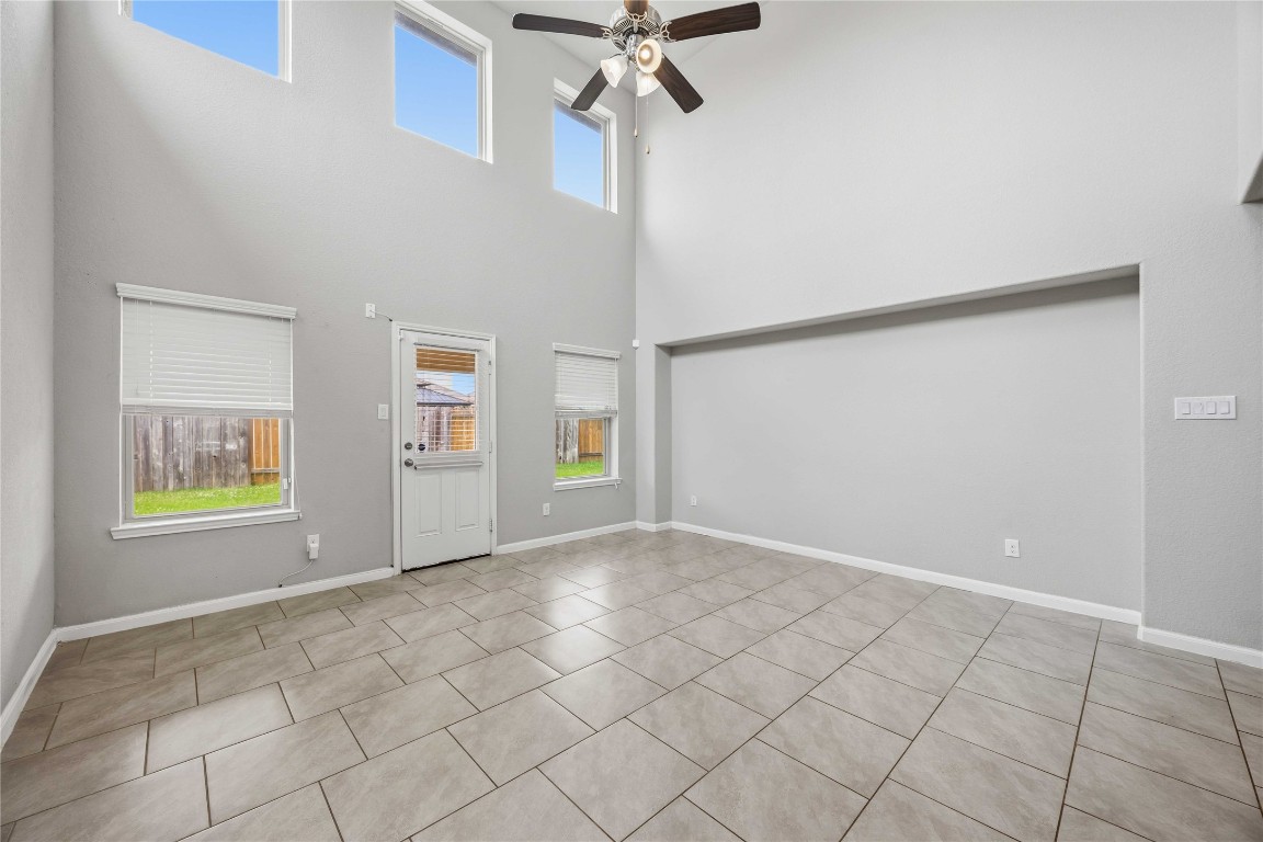 703 Autumn Flats Way Rosharon, TX 77583 - Photo 3 of 18 The heart of the home is this expansive living room, designed to an open-concept feel.The high ceiling creates an immediate sense of wide area. The vertical arrangement of windows, including high-set of horizintal beams, allows natural light in while maintaining privacy.