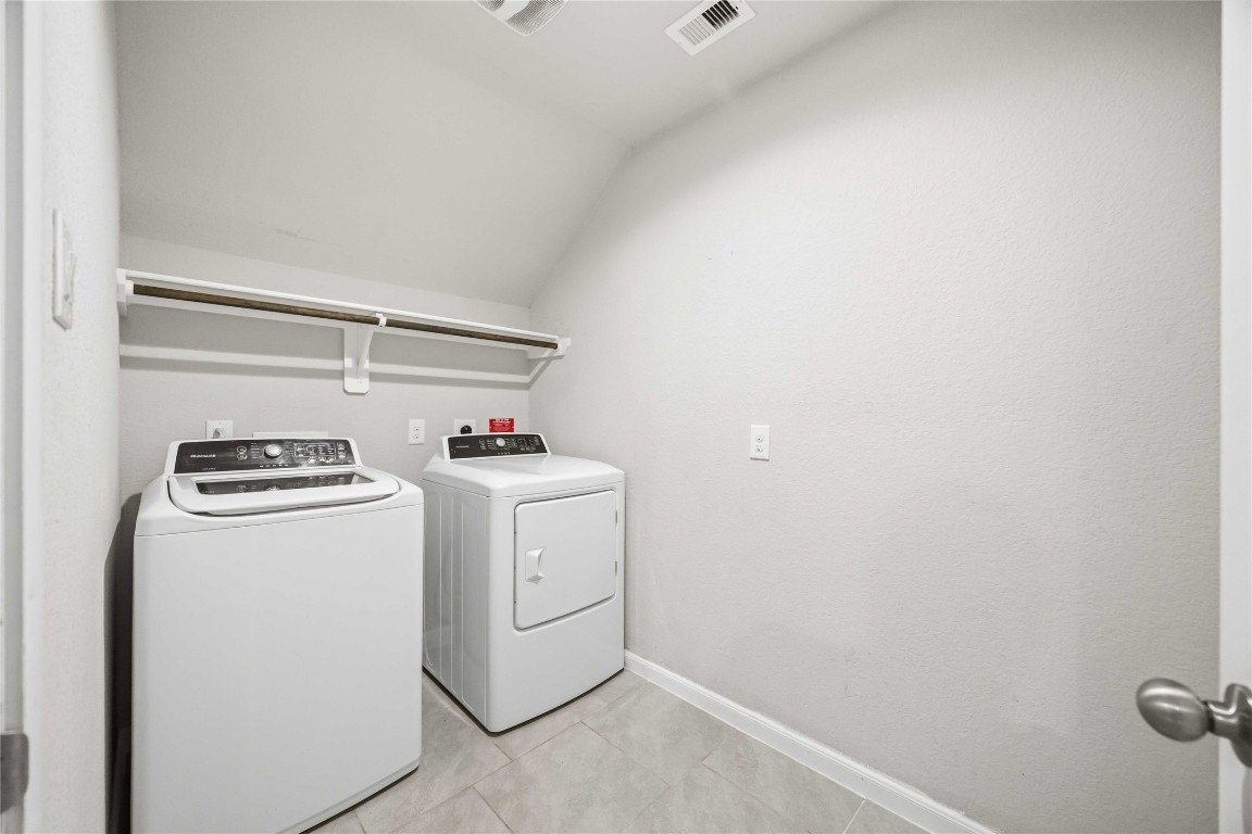 703 Autumn Flats Way Rosharon, TX 77583 - Photo 8 of 18 Functional and spacious laundry room. Includes a sturdy built-in overhead shelf and hanging rod, perfect for air-drying delicates or organizing freshly laundered clothes.Equipped with a dependable washer and dryer set, ready for immediate use.