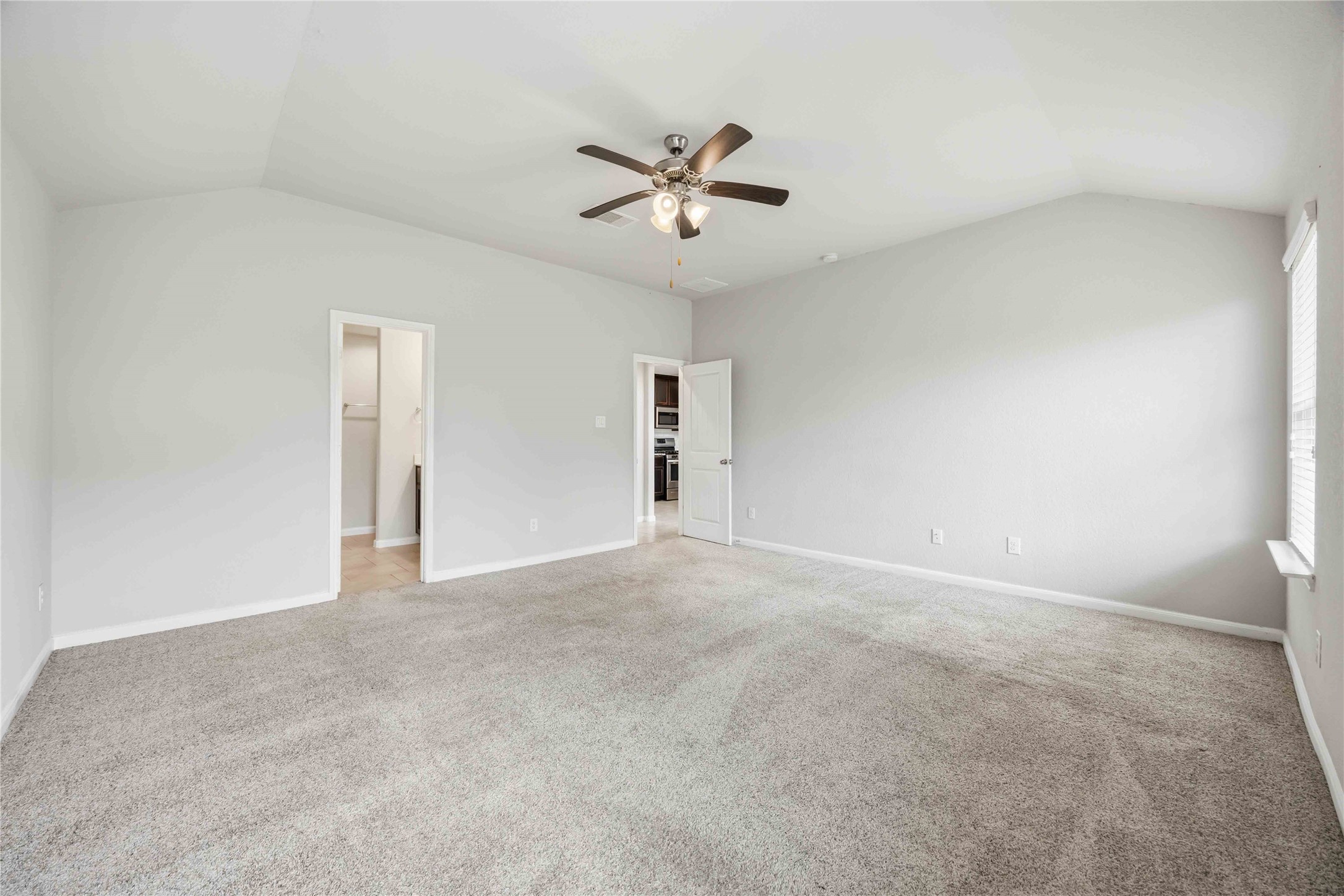 703 Autumn Flats Way Rosharon, TX 77583 - Photo 9 of 18 Spacious primary suite that offers a peaceful atmosphere with plenty of room for a king-sized bed and a private seating area. The room features direct access to a lavish en-suite bathroom and a walk-in closet.