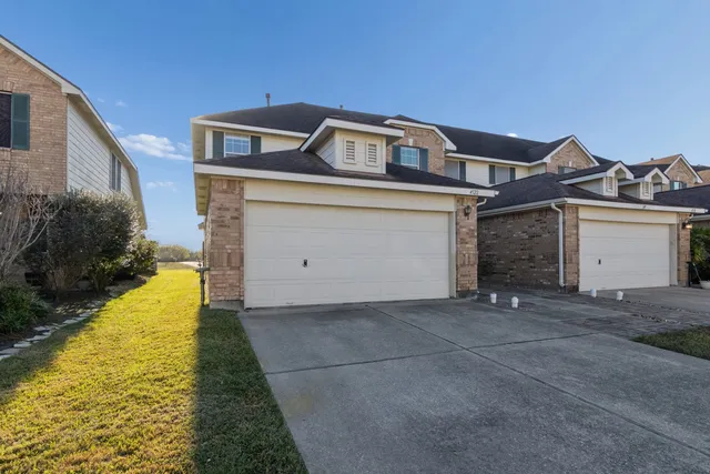 a view of a front of house with a yard and garage