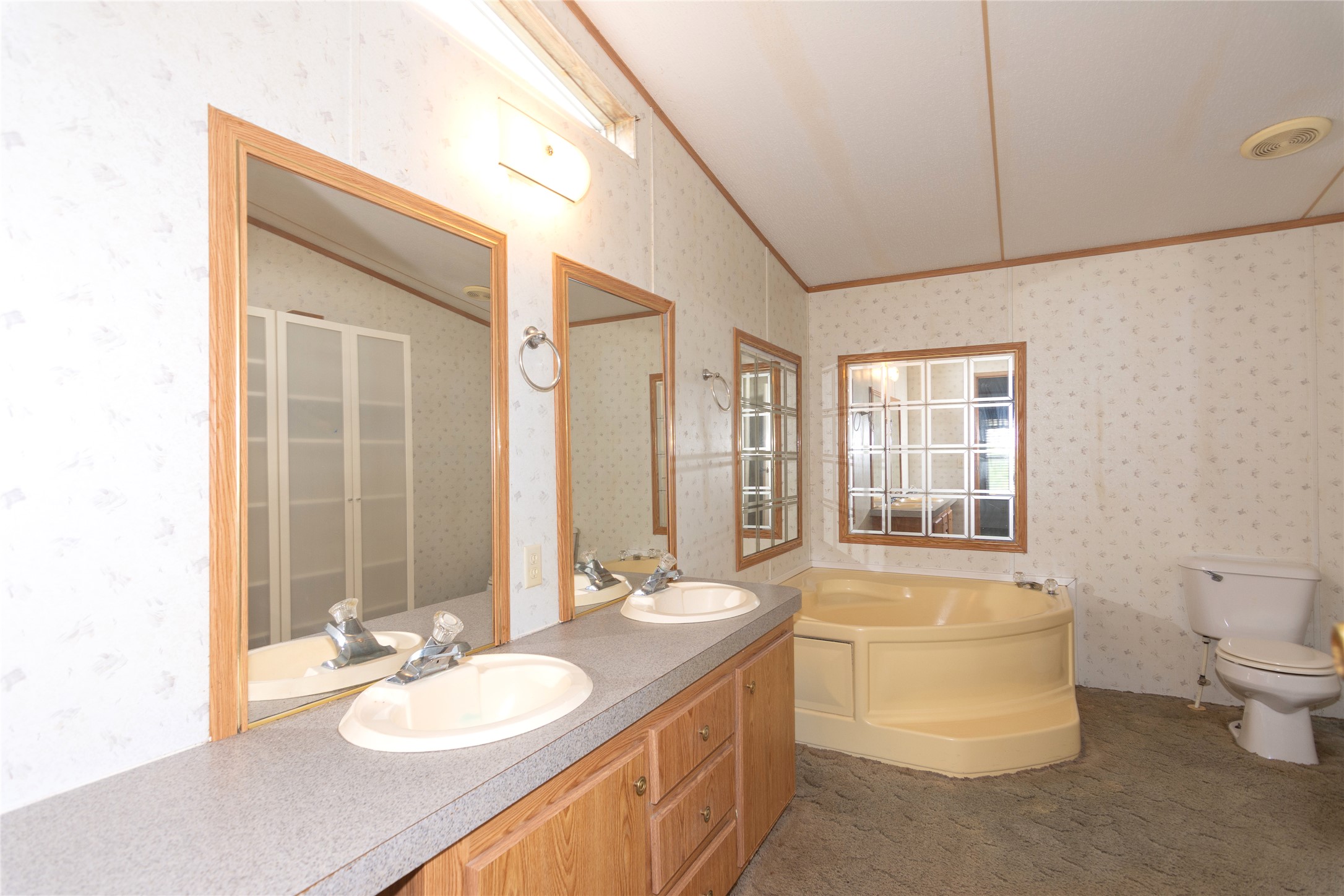 1 11209-tract Road Del Valle, TX 78617 - Photo 15 of 39 Bathroom with ornamental molding, a bath, wallpapered walls, lofted ceiling, and double vanity