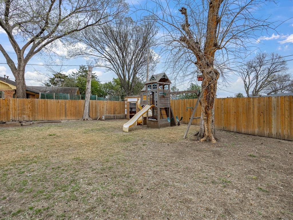 514 West Ridgewood Drive Garland, TX 75041 - Photo 31 of 39 View of play area with a fenced backyard