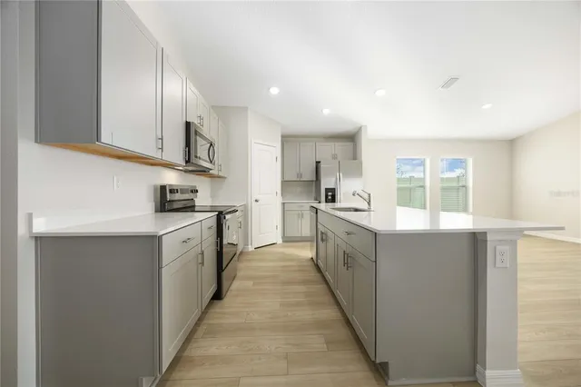 a large kitchen with stainless steel appliances lots of counter top space