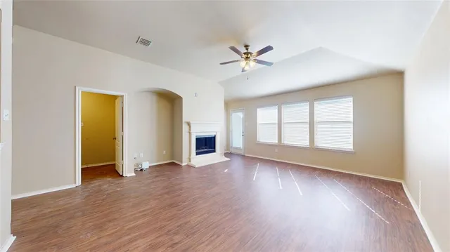 a view of an empty room with a window and wooden floor