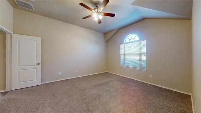 an empty room with a window and a ceiling fan