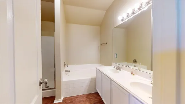 a bathroom with a tub sink and mirror