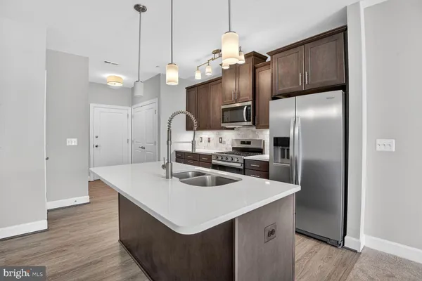 a kitchen with stainless steel appliances granite countertop a stove refrigerator and microwave
