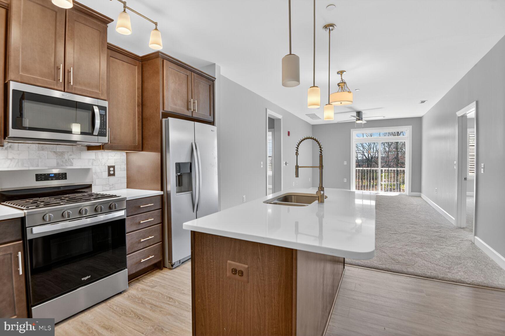 10530 Resort Road, Unit 210 Ellicott City, MD 21042 - Photo 7 of 35 a kitchen with stainless steel appliances granite countertop a stove refrigerator and microwave