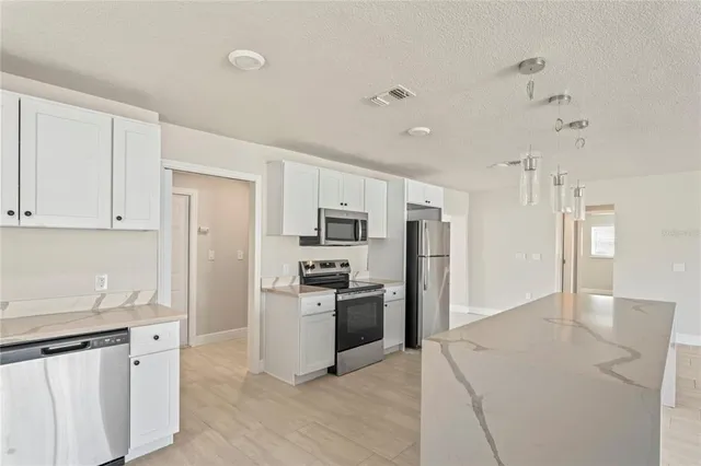 a kitchen with stainless steel appliances granite countertop a refrigerator and a sink
