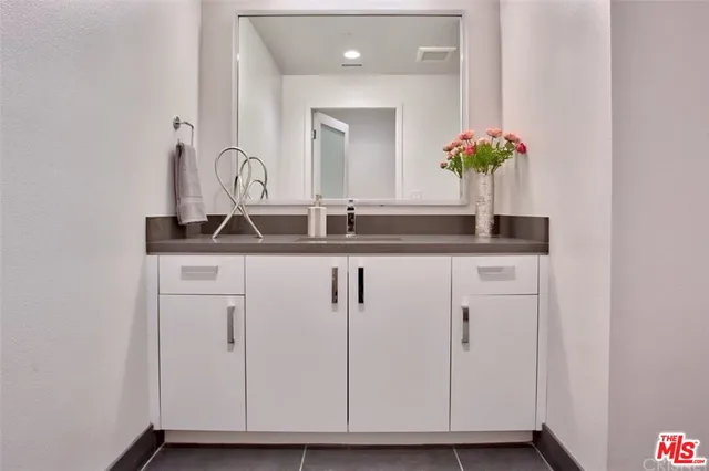 a bathroom with a granite countertop sink and a mirror