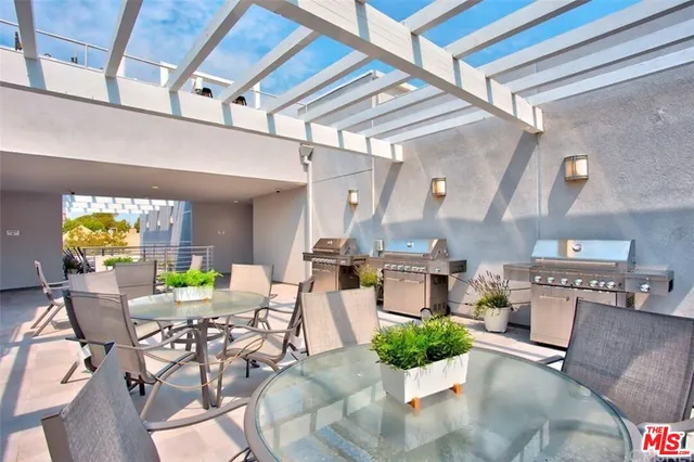 a view of a dining room with furniture a kitchen and stainless steel appliances