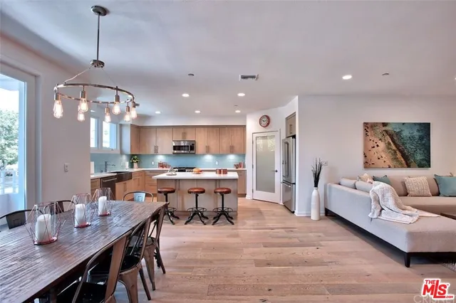 a living room with kitchen island furniture and a chandelier