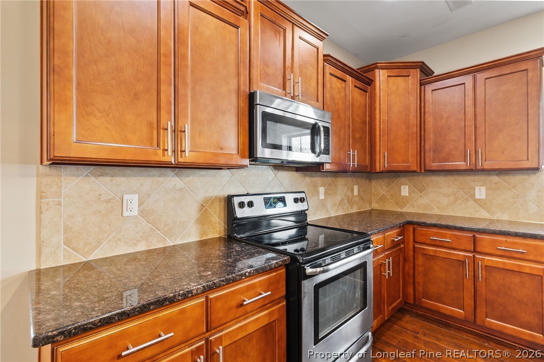 368 Exeter Drive Raeford, NC 28376 - Photo 12 of 49 a kitchen with stainless steel appliances granite countertop a sink a stove microwave and cabinets