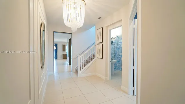a view of a hallway with closet and a chandelier fan
