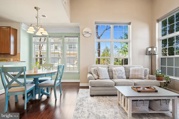 a living room with furniture dining table and a chandelier
