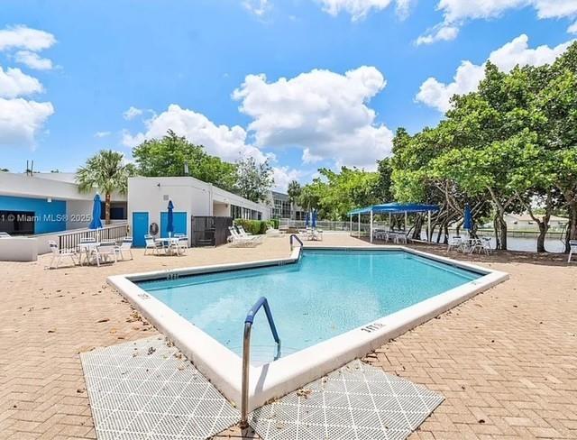 9401 Lime Bay Boulevard, Unit 114 Tamarac, FL 33321 - Photo 16 of 16 a view of a swimming pool with a lounge chairs