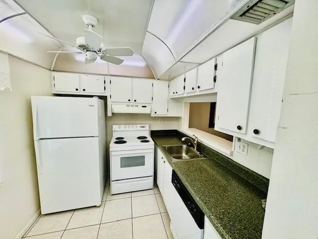 a kitchen with kitchen island a counter top space a stainless steel appliances a sink and cabinets