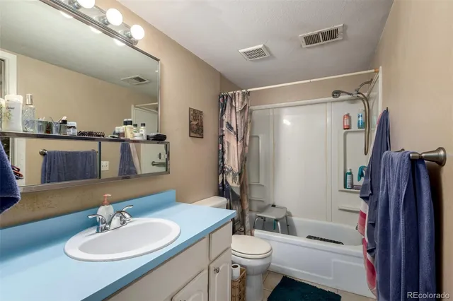 a bathroom with a sink a toilet a mirror and shower