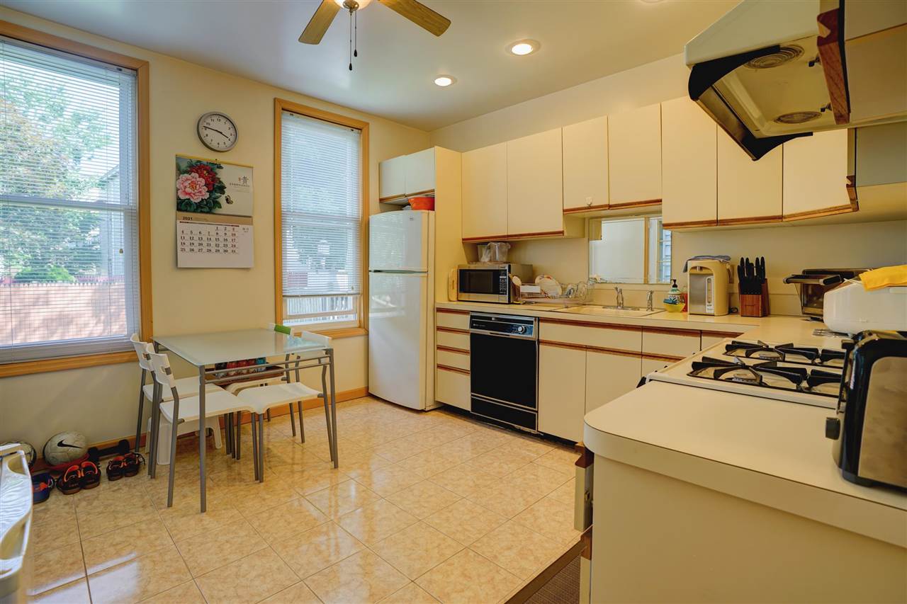 527 North 3rd Street East Newark, NJ 07029 - Photo 11 of 25 a kitchen with a sink a stove and chairs
