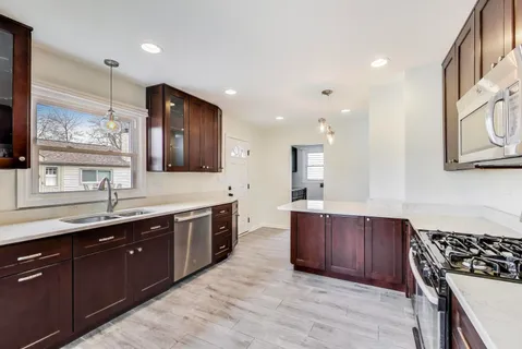 a large kitchen with stainless steel appliances granite countertop a sink and cabinets