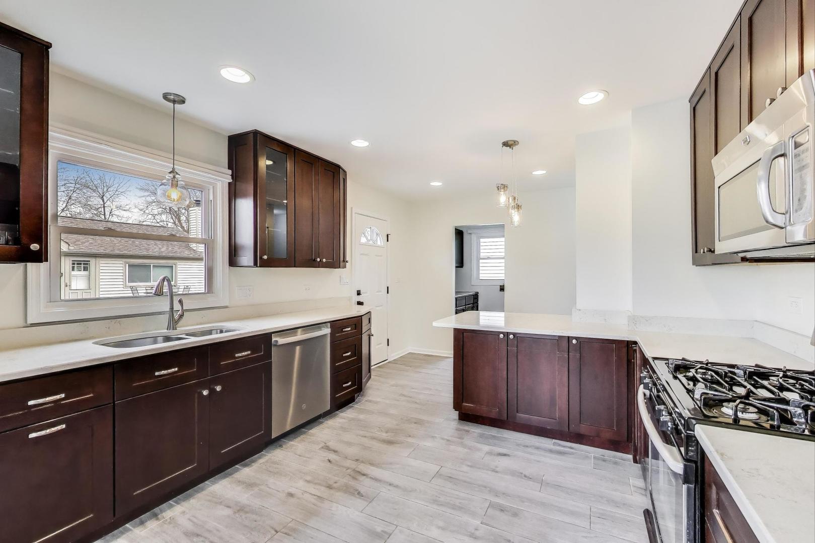 139 South Quentin Road Palatine, IL 60067 - Photo 2 of 23 a large kitchen with stainless steel appliances granite countertop a sink and cabinets