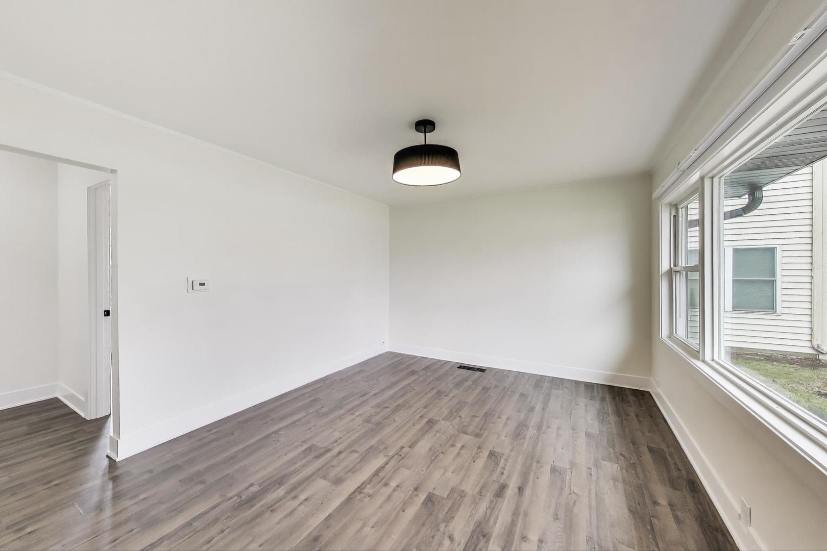 139 South Quentin Road Palatine, IL 60067 - Photo 5 of 23 an empty room with wooden floor and windows
