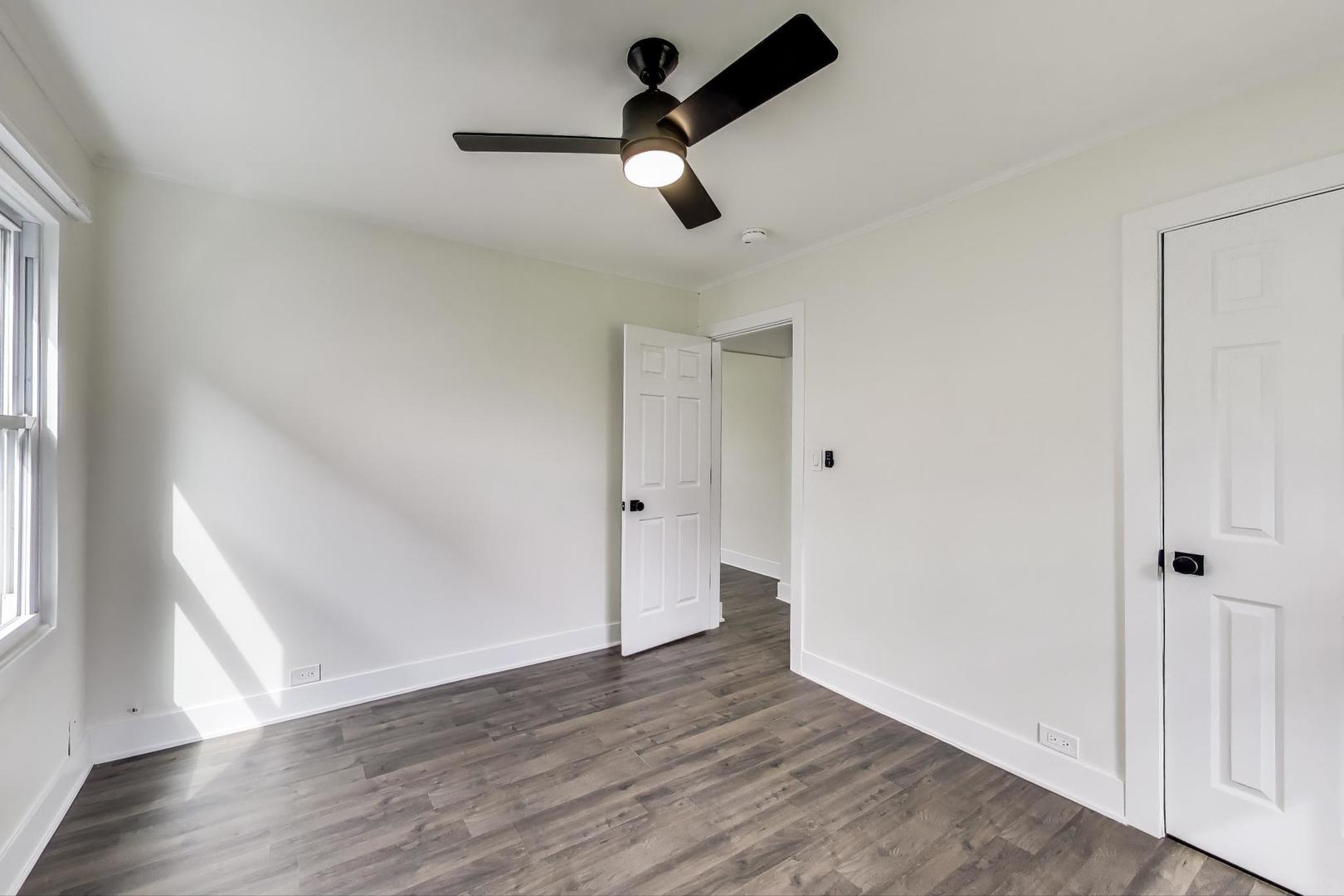 139 South Quentin Road Palatine, IL 60067 - Photo 7 of 23 an empty room with wooden floor cabinet and windows