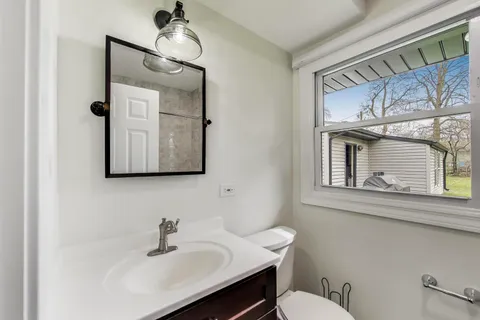 a bathroom with a toilet a sink and mirror