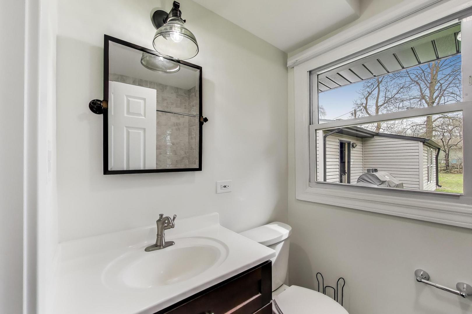 139 South Quentin Road Palatine, IL 60067 - Photo 8 of 23 a bathroom with a toilet a sink and mirror
