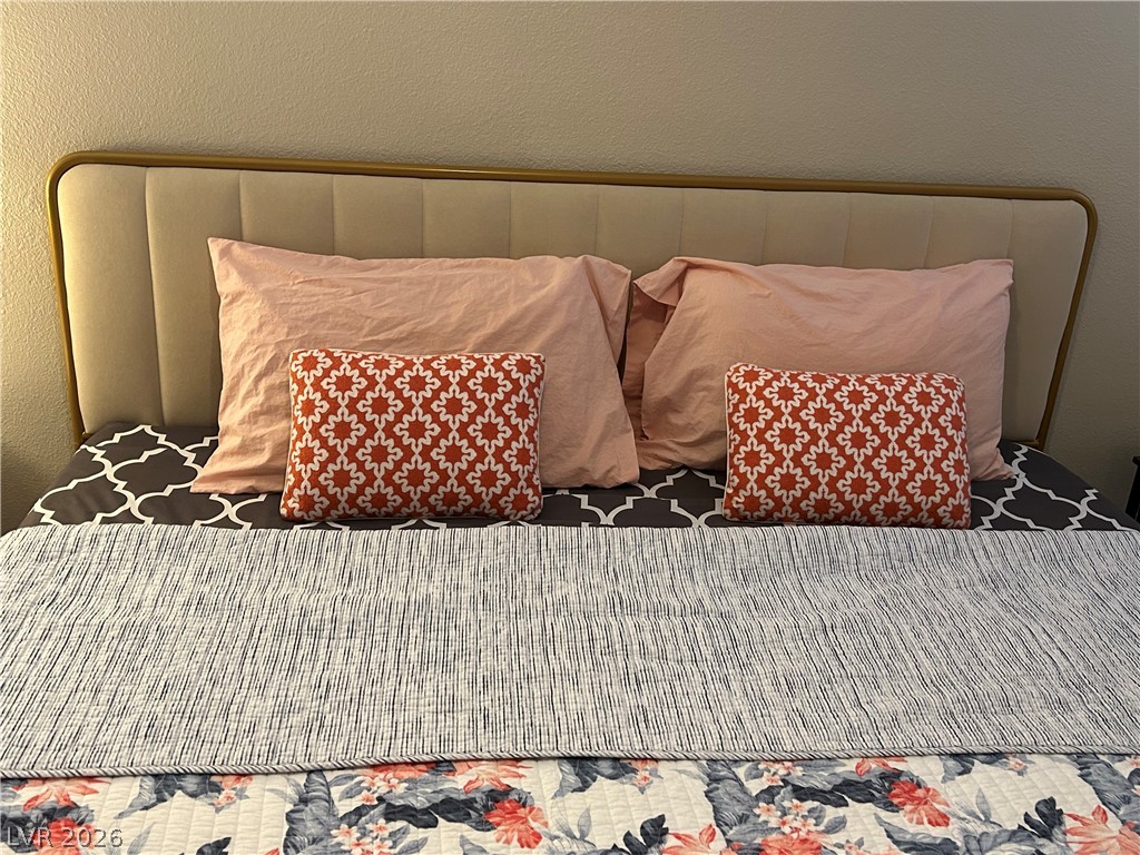 267 Westwind Road Henderson, NV 89074 - Photo 16 of 16 An upholstered headboard with sleek lines anchors this well-appointed bedroom.