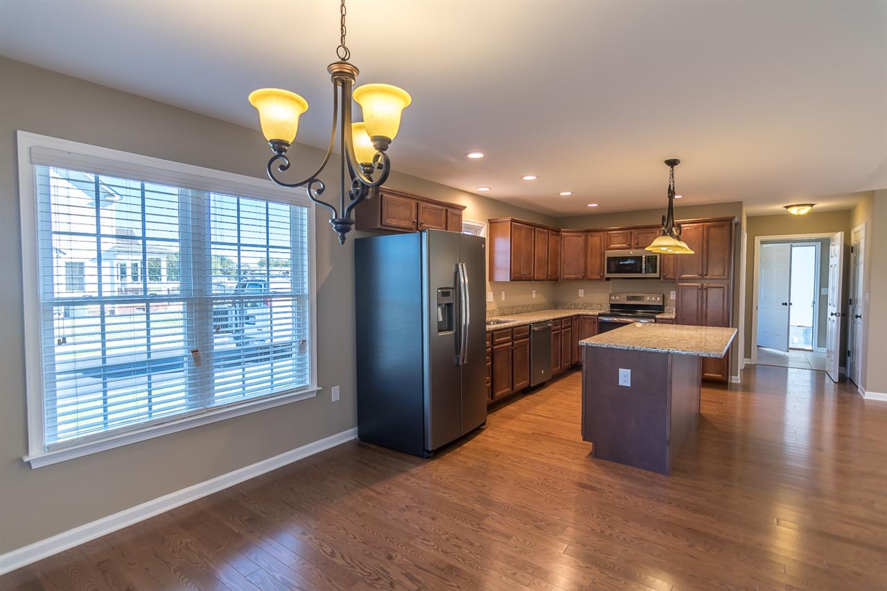 900 Riverside Avenue Grottoes, VA 24441 - Photo 14 of 37 a kitchen with stainless steel appliances granite countertop a refrigerator a sink dishwasher and a dining table with wooden floor