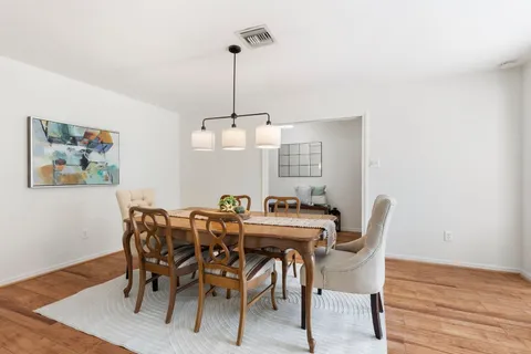 a living room with furniture and a potted plant with wooden floor