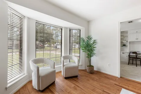 a view of a dining room with furniture a chandelier and window