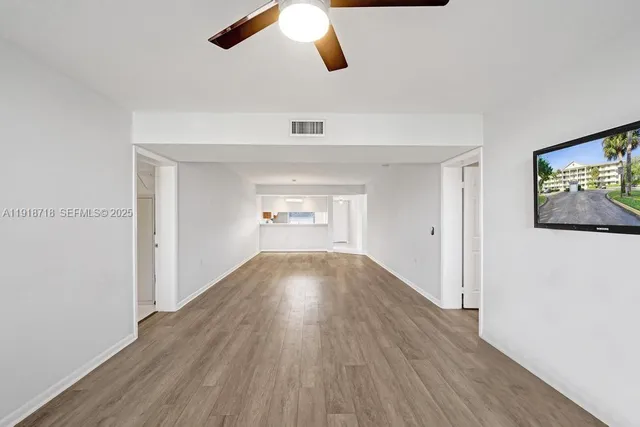 a view of empty room with wooden floor