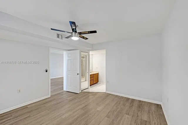 a view of a livingroom with wooden floor and a ceiling fan